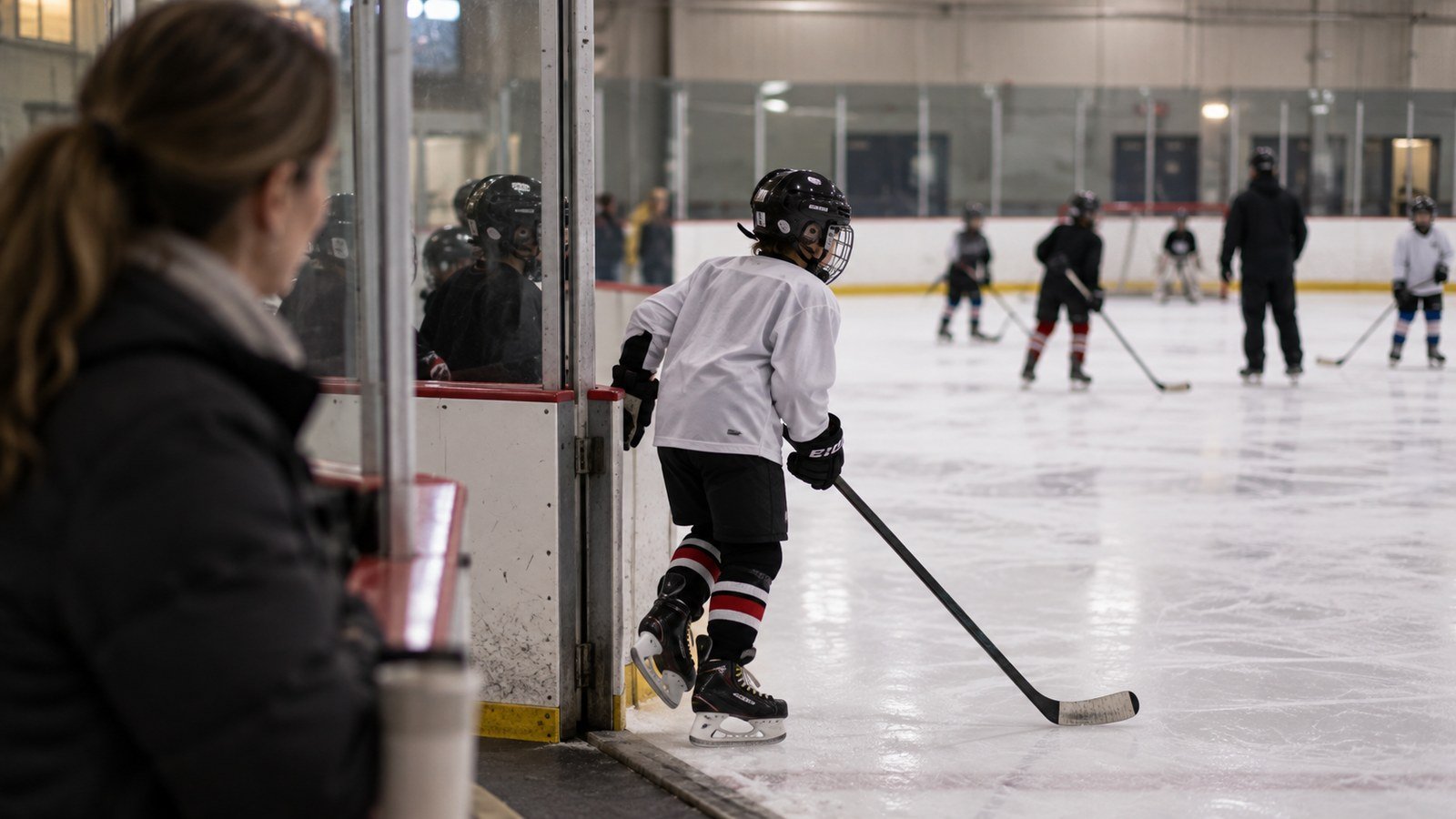Enfant qui entre sur la glace pour un entraînement de hockey dans un aréna du Québec, le type de programme qui soulève la question des frais particuliers partagés